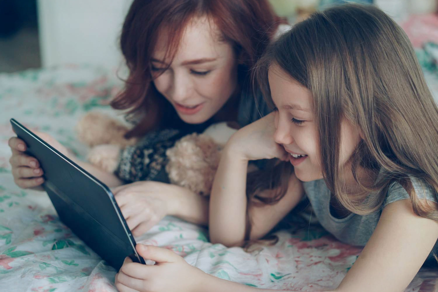 Oglądanie tableta mamy z córką na łóżku