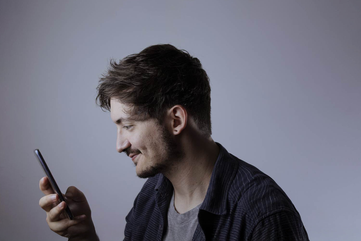 Mężczyzna zadowolony z szybkości przeglądanego smartfona HONOR